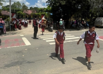 Personel Ditsamapta Polda Kaltara Bantu Siswa SDN 020 Tanjung Selor Menyeberang Jalan