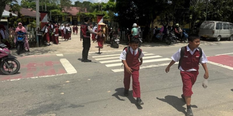 Personel Ditsamapta Polda Kaltara Bantu Siswa SDN 020 Tanjung Selor Menyeberang Jalan