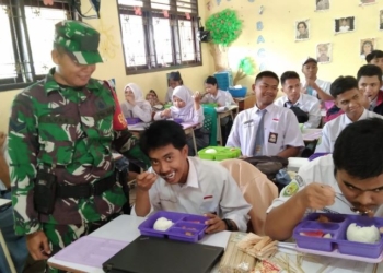 Sukeskan Program Makan Bergizi Gratis, Babinsa Kodim 0907/Trk Dampingi Pendistribusian