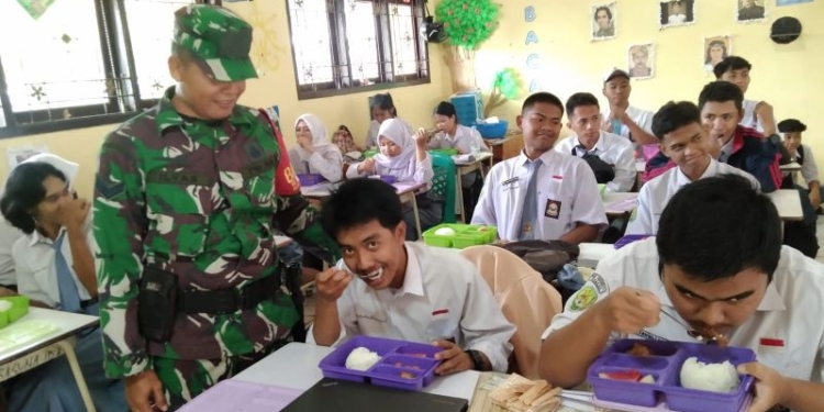 Sukeskan Program Makan Bergizi Gratis, Babinsa Kodim 0907/Trk Dampingi Pendistribusian