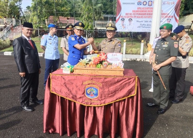 Plt Wali Kota Tarakan, Ibnu Saud menerima potongan tumpeng dari Kasatpol PP dan PMK Tarakan. (foto: jendelakalrara.co)