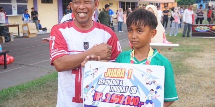 Bupati Bulungan, Syarwani, S.Pd, M.Si (kiri) serahkan uang pembinaan simbolis kepada juara. (foto: Bagian Prokopim Setda Bulungan)